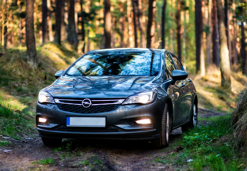 Sälj bil Gnosjö En Mazda som kör genom en stig i skogen
