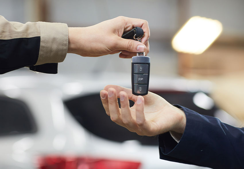 verkstad En verkstadsmekaniker som ger bilnycklarna till en kund